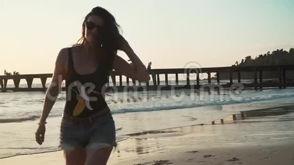 快乐的女人在日落时享受海滩度假视频的预览图