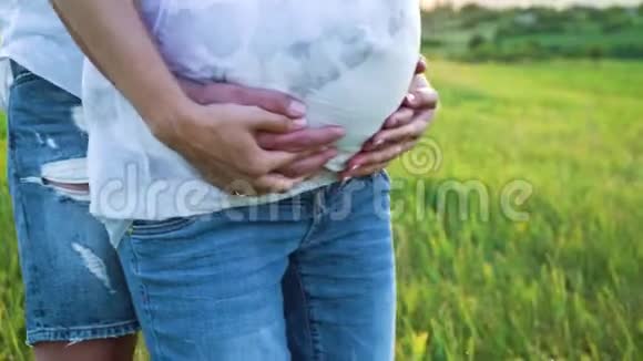 父母双手触摸怀孕的腹部自然特写视频的预览图