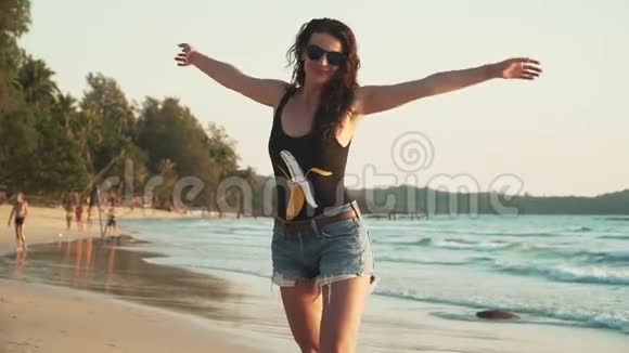 快乐的女人在日落时享受海滩度假视频的预览图