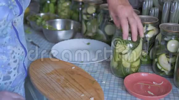 特写镜头老妇人的双手转动厨房上装满蔬菜的玻璃罐视频的预览图