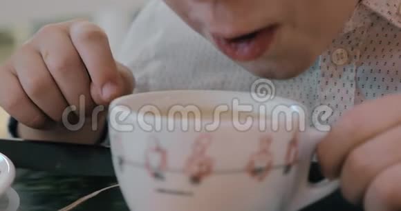 男孩吹着热茶冷却它视频的预览图