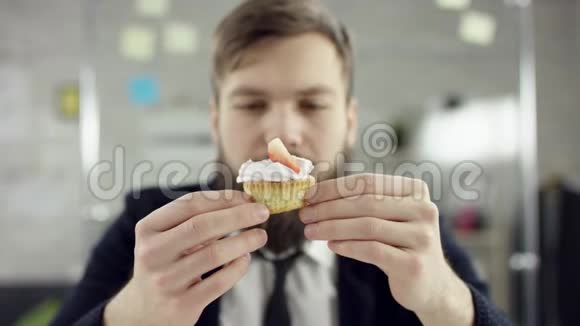 悲伤迷人的商人在办公室庆祝孤独的生日他在一个小蛋糕上吹蜡烛他是视频的预览图
