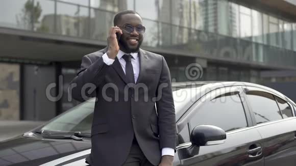 成功的男人穿着昂贵的西装在电话中交流站在他的车附近视频的预览图