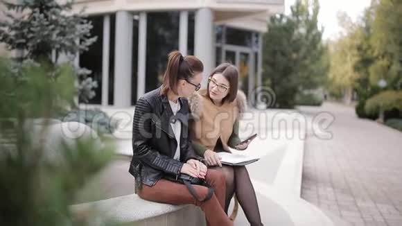 两个商务女性坐在商务中心附近讨论工作文件视频的预览图