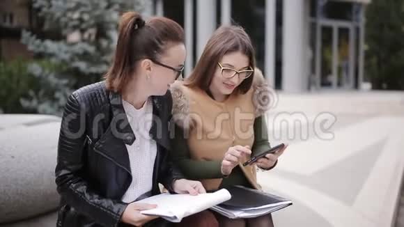 两位商务女性在商务中心附近的街道上交谈讨论新的商务项目视频的预览图