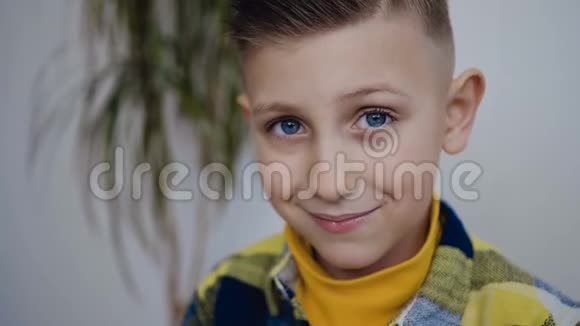 一个看着镜头的时髦小男孩的近镜头他有着美丽的蓝眼睛喝着可口的饮料视频的预览图