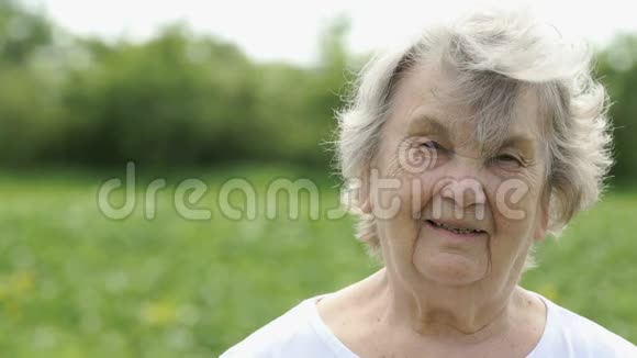 微笑成熟的老年妇女使你的头发挺直视频的预览图