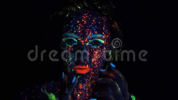 时尚模特女性在霓虹灯荧光化妆霓虹灯中一个女孩的肖像脸上涂着光辉视频的预览图