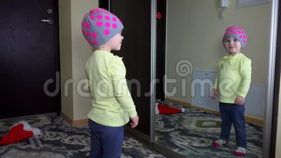 戴帽子的顽皮女孩在镜子里亲吻自己快乐的童年视频的预览图