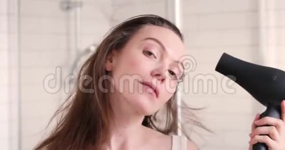 女式吹风机和浴室里的微笑镜视频的预览图