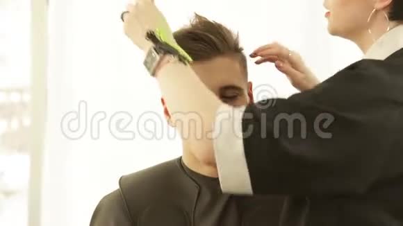 发型师在美发沙龙剪干后制作男性发型专业发型师视频的预览图