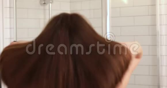 女人把她光滑的长发扎成马尾辫视频的预览图