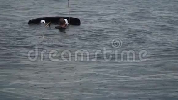 一个拿着叫板的年轻人躺在水上视频的预览图