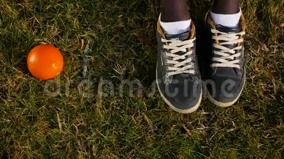 穿着白色袜子和运动鞋的女性脚在绿色草地上橙色的位置移动姿势和脚踩视频的预览图