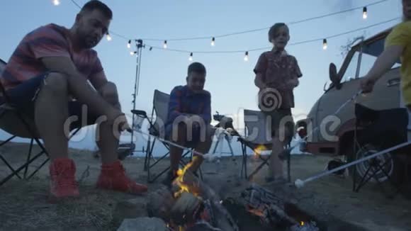 一家人在篝火上炸棉花糖视频的预览图