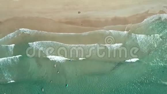 在热带白色沙滩和冲浪板的冲浪者上可以看到海浪的顶部空中无人驾驶飞机观4k海射视频的预览图