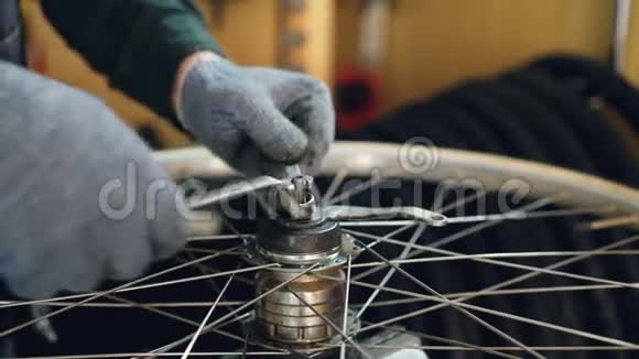 专业仪器在自行车车轮机构中的油手手套紧合镜头视频的预览图