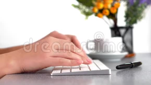 特写女性手的视频在PS键盘上打字在办公室的桌子上视频的预览图