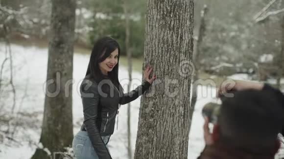美丽的西班牙裔拉丁女孩向雪地公园的摄影师倾斜视频的预览图