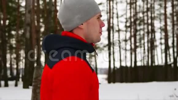 冬天一个穿着红色夹克的年轻运动男子在新鲜空气中跑步慢慢视频的预览图