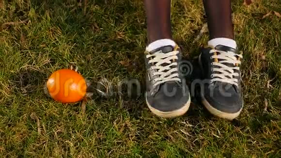 穿着白色袜子和运动鞋的女性脚在绿色草地上橙色的位置移动姿势和脚踩视频的预览图
