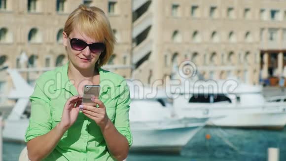 女人用游艇在旅游城市天际线上打短信视频的预览图