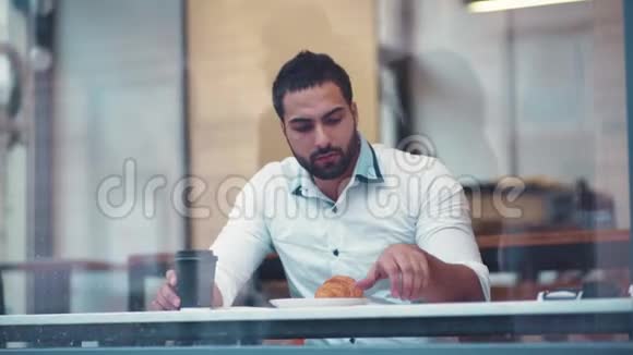 慢动作的一个华丽的年轻人坐在咖啡馆A接电话现代新技术视频的预览图