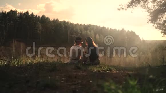 年轻夫妇穿着民俗服装坐在一块岩石上俯瞰森林视频的预览图