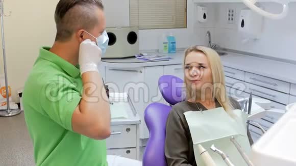 牙科医生从病人身上取下手术面罩和保护组织的4k镜头视频的预览图