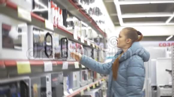 女人在电子超市选择厨房电器视频的预览图