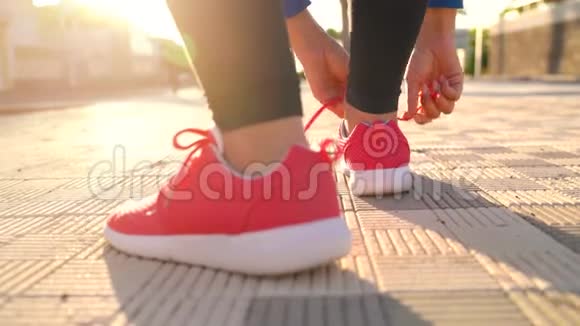 在日落时分女人系鞋带沿着棕榈大道奔跑背面视频的预览图