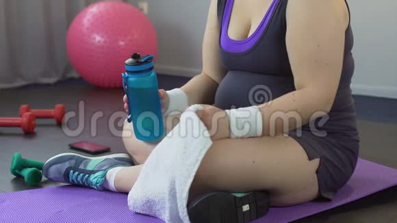 在疲惫的家庭锻炼后丰满的女士恢复水平衡和呼吸视频的预览图