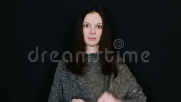 女人黑发将拉瓦利埃麦克风连接到黑色背景上的衬衫上视频的预览图