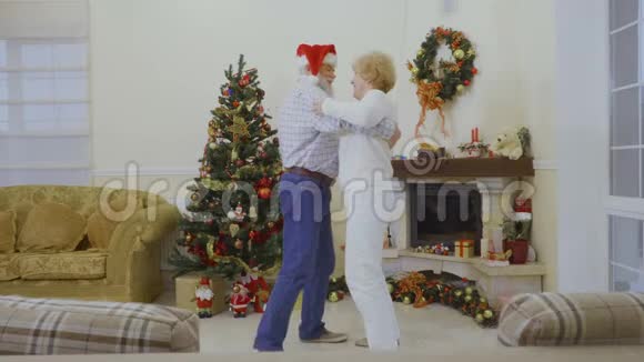 年长夫妇在圣诞树附近跳舞视频的预览图