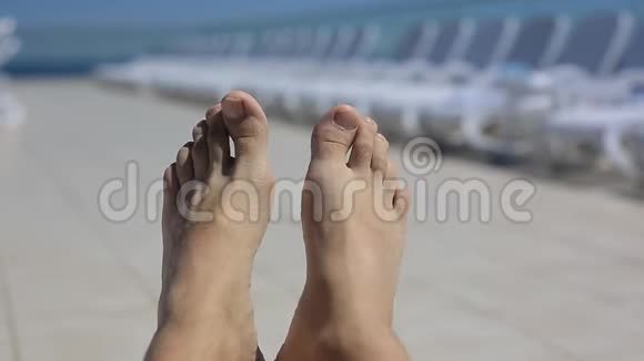 在游泳池旁阳光明媚的背景下男人双腿旅游健康生活方式视频的预览图
