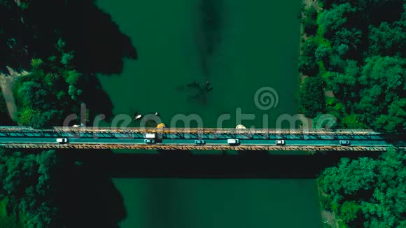 空中无人驾驶飞机射击沿车辆向前飞行跨越公路桥梁越过河流顶部视图视频的预览图