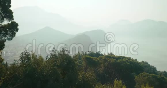 从上面看黑山的一些地方覆盖着岩石山脉和湖泊的浓雾视频的预览图