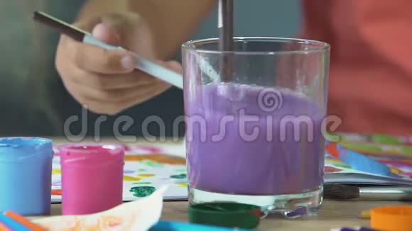 小女孩的洗手画刷在五颜六色的水创意有趣的时间视频的预览图