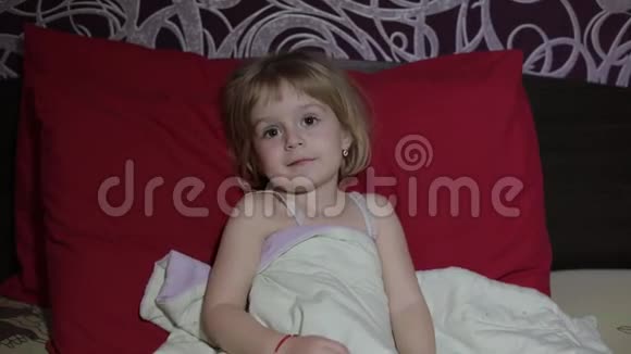 小女孩在床上看电视视频的预览图