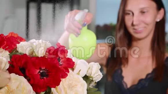 年轻的女花店在花束上喷水特写视频的预览图