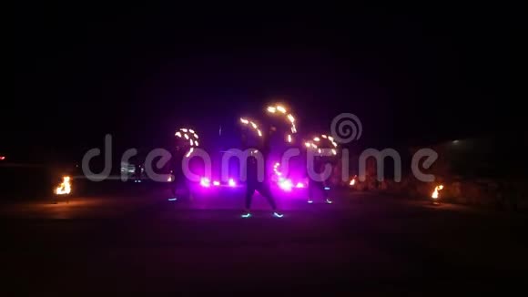 消防表演三位艺术家拉开了演出的序幕男孩和女孩在夜晚用火表演舞蹈视频的预览图