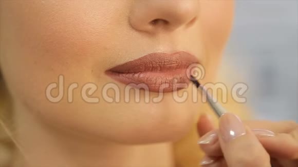 化妆师在模特的嘴唇上涂了一支浅口红视频的预览图