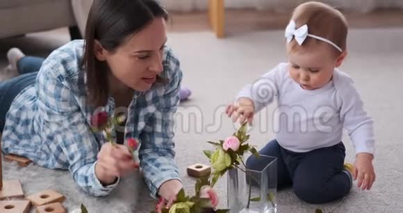 母亲和女儿在花瓶里摆花视频的预览图