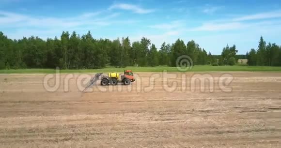 喷洒肥料的拖拉机拖车在收获的农田上移动视频的预览图