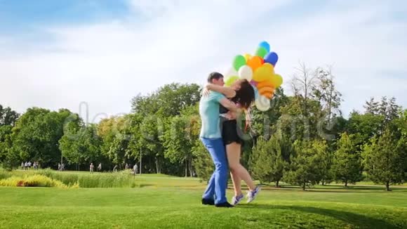 慢动作视频年轻人举着五颜六色的气球旋转女友视频的预览图