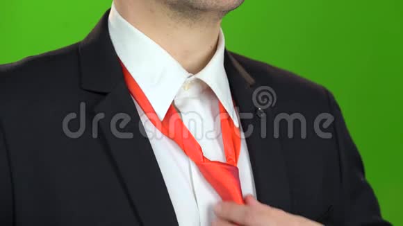 男人手紧了脖子下面的领带绿色屏幕关门视频的预览图