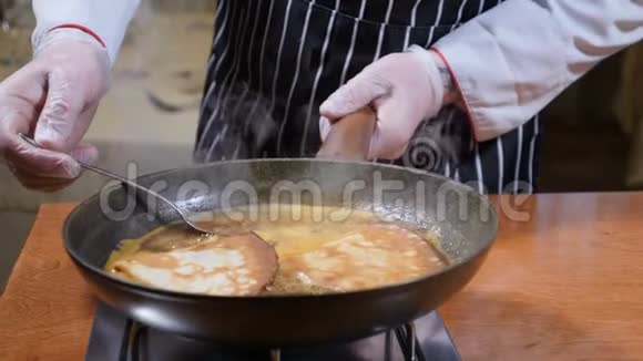 餐厅烹饪理念烧焦糖酱中的煎饼用汤匙把厨师搅拌好的酱汁合上慢动作视频的预览图