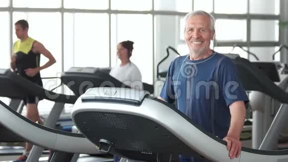 微笑的老人在健身房锻炼视频的预览图