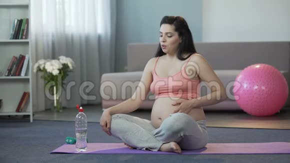 怀孕最后阶段的女士做瑜伽喝水安全分娩视频的预览图