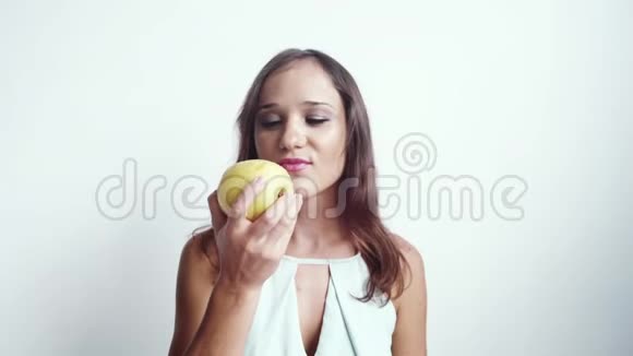 美丽的年轻快乐的女人吃绿色的苹果水果孤立在白色背景上3840x2160视频的预览图
